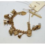 A 9ct gold charm bracelet and gold charms, and a 9ct gold cruciform pendant.