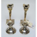 Two pairs of antique silver candlesticks.