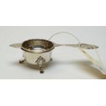 A George V silver tea strainer and stand.