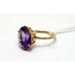 An amethyst and yellow-metal dress ring.