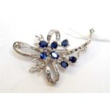 A high-carat white metal, diamond, and sapphire brooch.