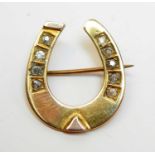 An antique diamond and yellow metal horseshoe brooch.