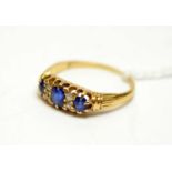 A yellow-metal, diamond, and sapphire dress ring.