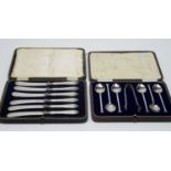 A cased set of six George V silver teaspoons and sugar tongs, and a cased set of butter knives.