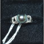 A contemporary 9ct white gold, black pearl and diamond cocktail ring