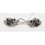 A pair of high carat white metal, diamond, and sapphire statement ear clips.