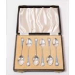 A cased set of six enamelled silver coffee spoons.