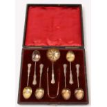 An Edwardian cased set of silver tea spoons, strainer and sugar tongs.