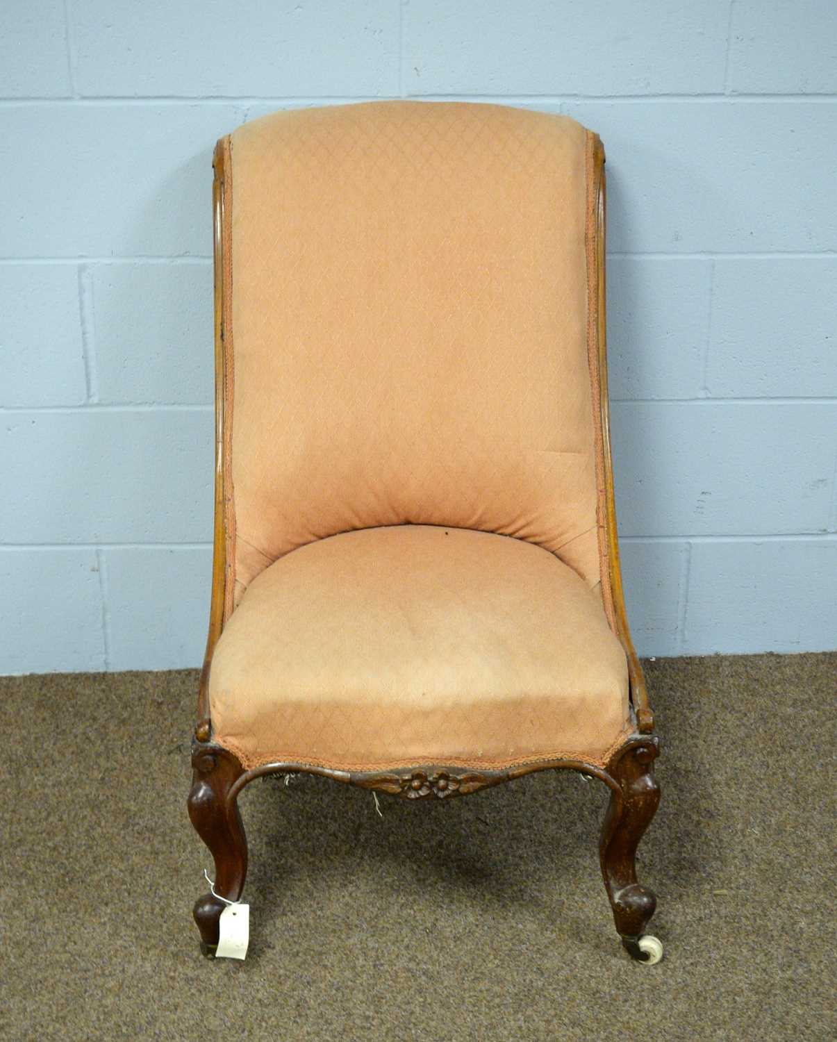 A late Victorian walnut slipper chair, upholstered in peach fabric.