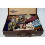 A collection of costume jewellery in a vintage travel case.