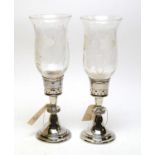 A pair of silver and etched glass hurricane candlesticks.