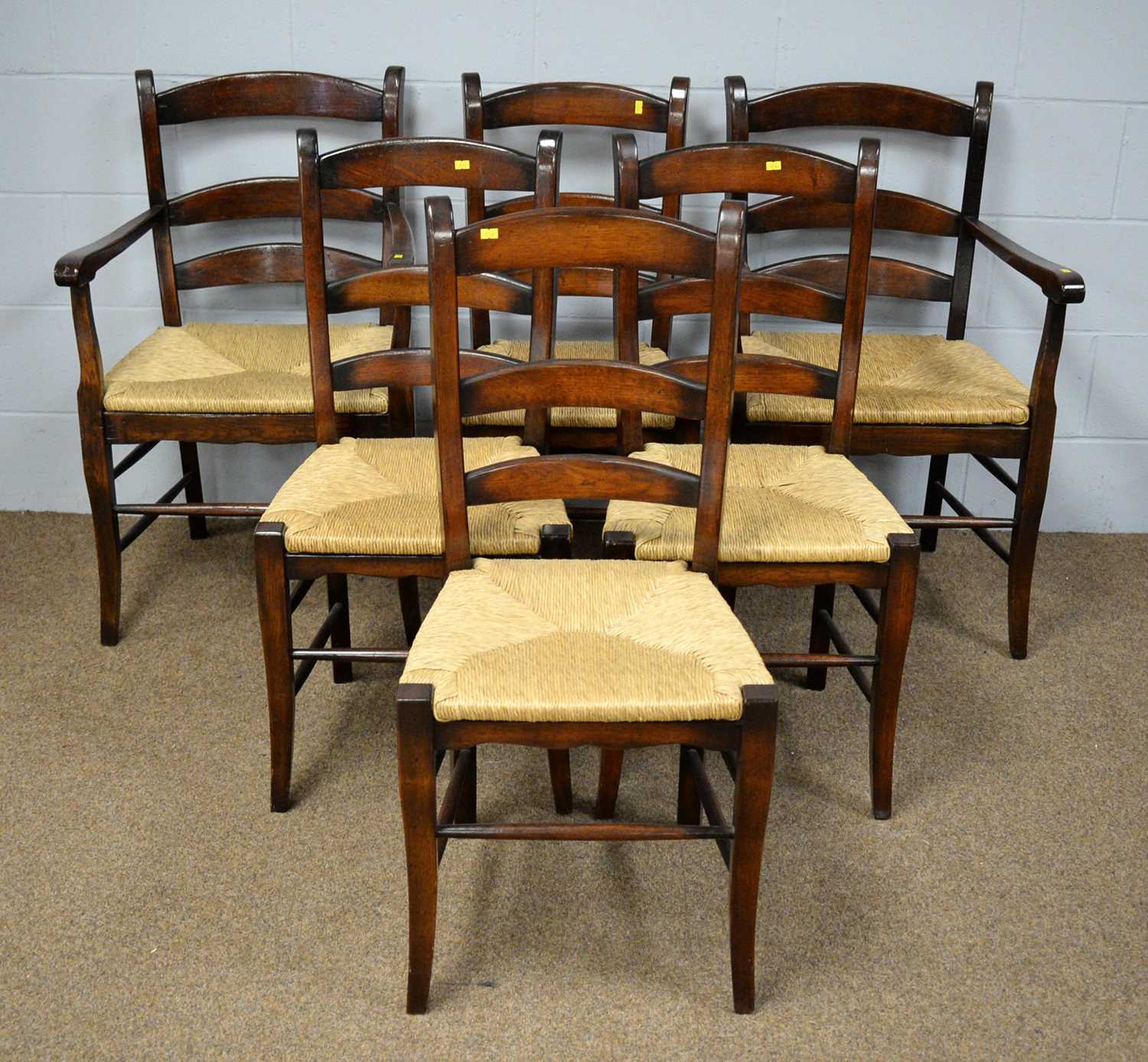 A set of six rush seat ladder-back dining chairs.