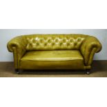 A late Victorian green buttoned and studded leather drop-end Chesterfield sofa.