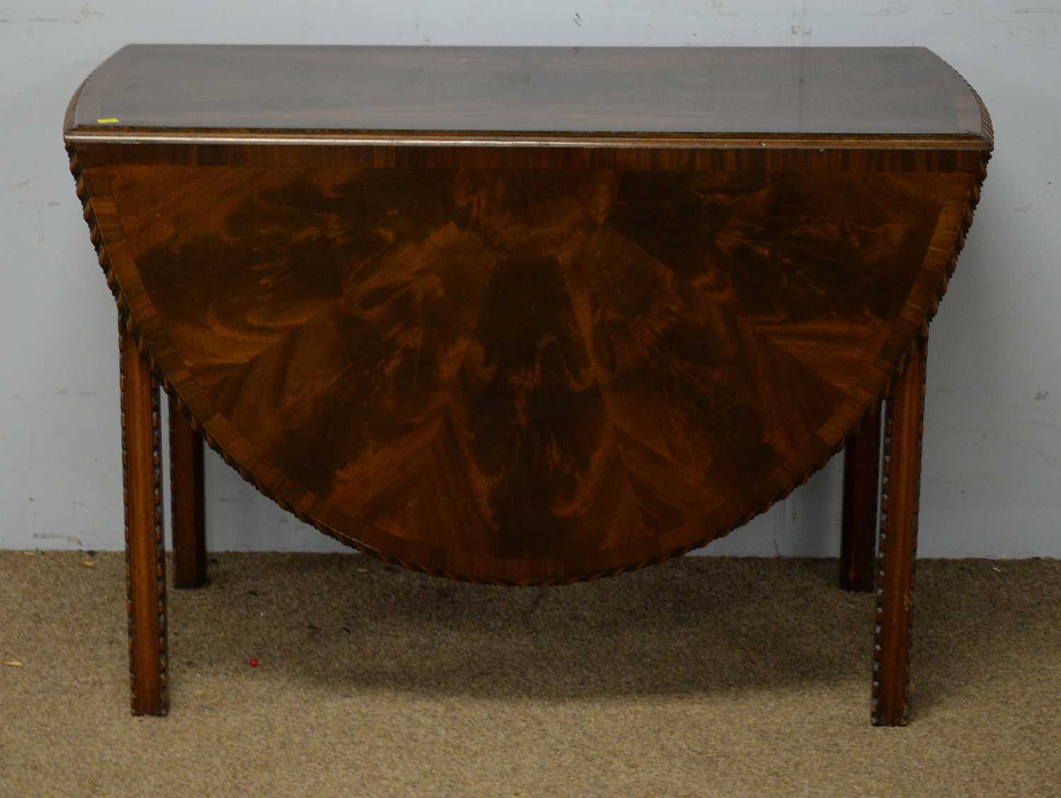 A Georgian-style mahogany gateleg dining table.