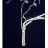 A diamond set 9ct white gold baton pendant,