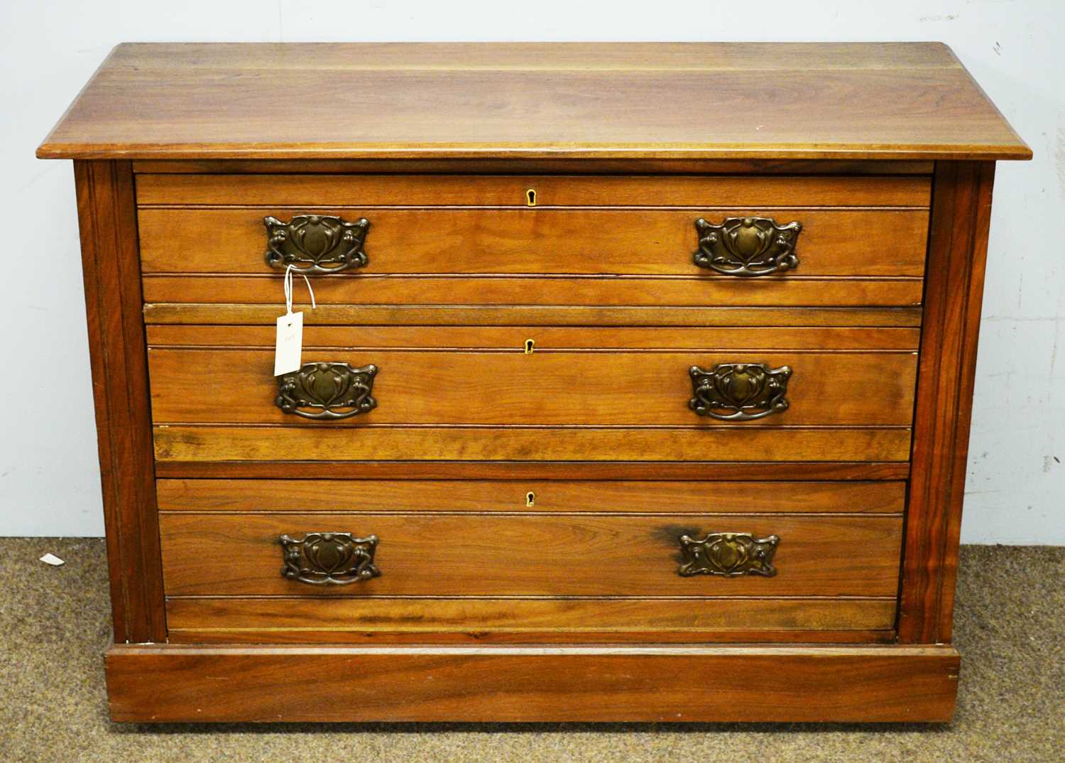 An Edwardian walnut three drawer chest.