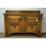 An early 20th Century Arts & Crafts carved oak sideboard.