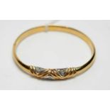 A diamond set 9ct yellow gold bangle,