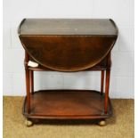 Ercol: an elm Windsor three-tier drinks trolley.