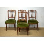 Four late Victorian carved walnut dining chairs.