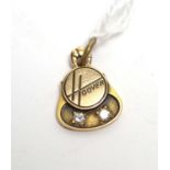 A yellow metal Hoover pattern pendant