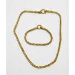 A yellow-metal fancy curb-link neck chain and bracelet.