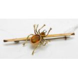 A yellow-metal bug brooch modelled as a spider.