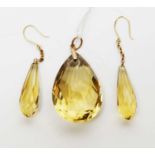 A citrine pendant and earrings on yellow-metal.