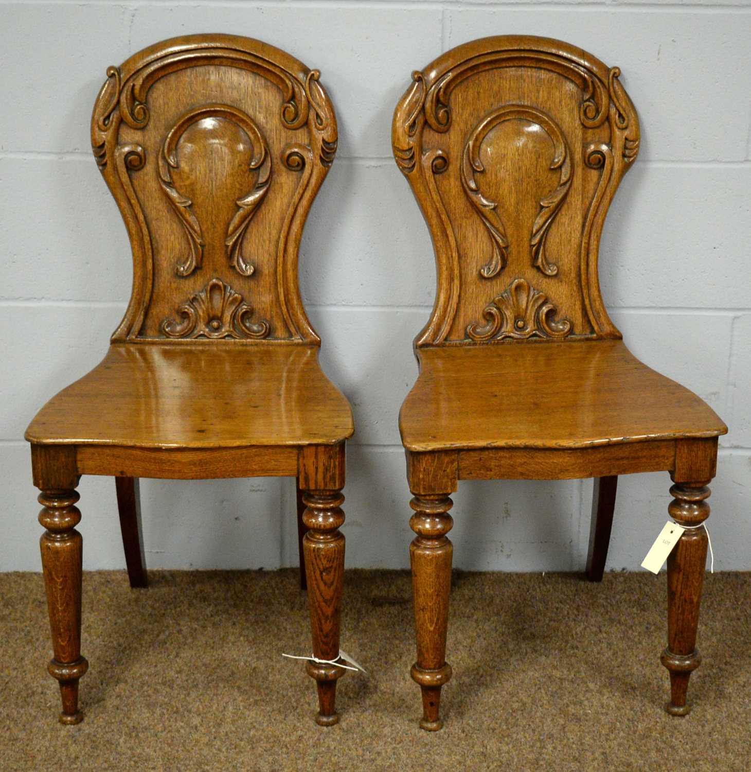 A pair of early Victorian oak hall chairs