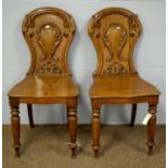 A pair of early Victorian oak hall chairs