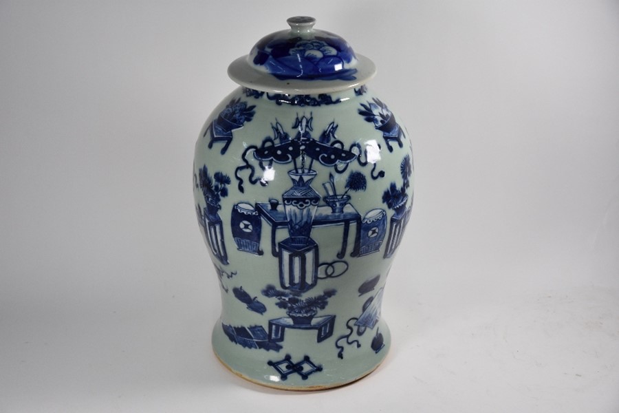 A Chinese blue and white celadon ground 'Hundred Antiques' pattern jar and cover