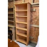 A modern tall light oak open bookcase