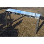A contemporary narrow console table with silver paint-finish frame and bevelled mirror panels