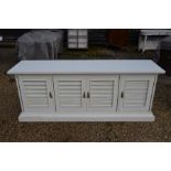 A large white painted sideboard with louvre panelled doors