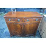 A mahogany crossbanded serpentine front cabinet