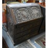 An antique oak bureau, profusely relief carved