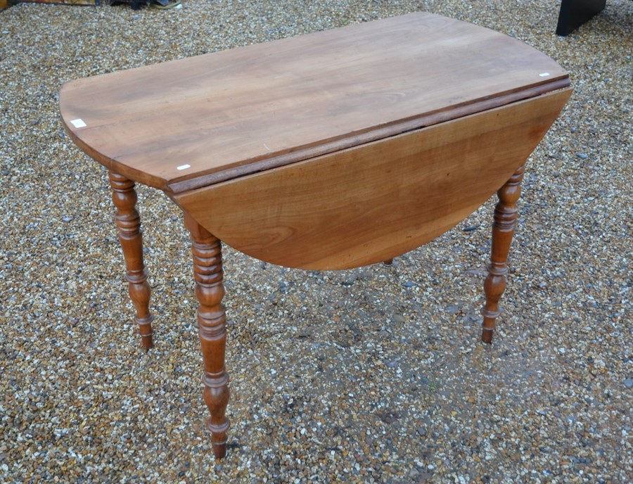 A 19th century fruitwood drop leaf table on turned supports