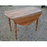 A 19th century fruitwood drop leaf table on turned supports