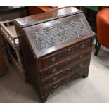 A profusely carved mahogany fall front bureau