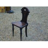 An antique carved mahogany hall chair