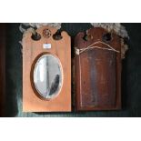 A pair of early 20th century stained pine framed bevelled oval wall mirrors