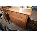 A modern stained pine chest of three long drawers