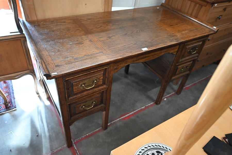 A panelled oak kneehole desk with five drawers