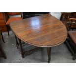 An early 20th century oak drop leaf dining table on barleytwist gateleg action supports