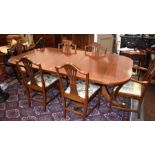 A Georgian style crossbanded mahogany extending dining table and chairs