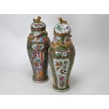 A pair of 19th century Chinese Canton famille rose baluster vases and covers, late Qing