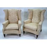 A pair of Georgian style wing armchairs with turned front legs