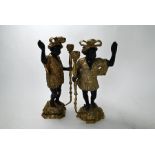 A pair of bronze candlesticks, modelled as ornately-dressed attendants