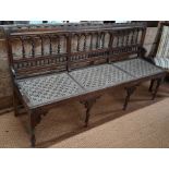An old Anglo-Indian teak veranda bench with caned panels