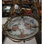 A brass-framed ceiling light with floral-decorated glass bowl